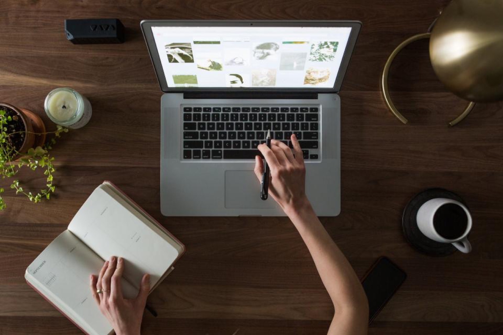 Bureau vu de dessus : ordinateur portable affichant un site, agenda et café