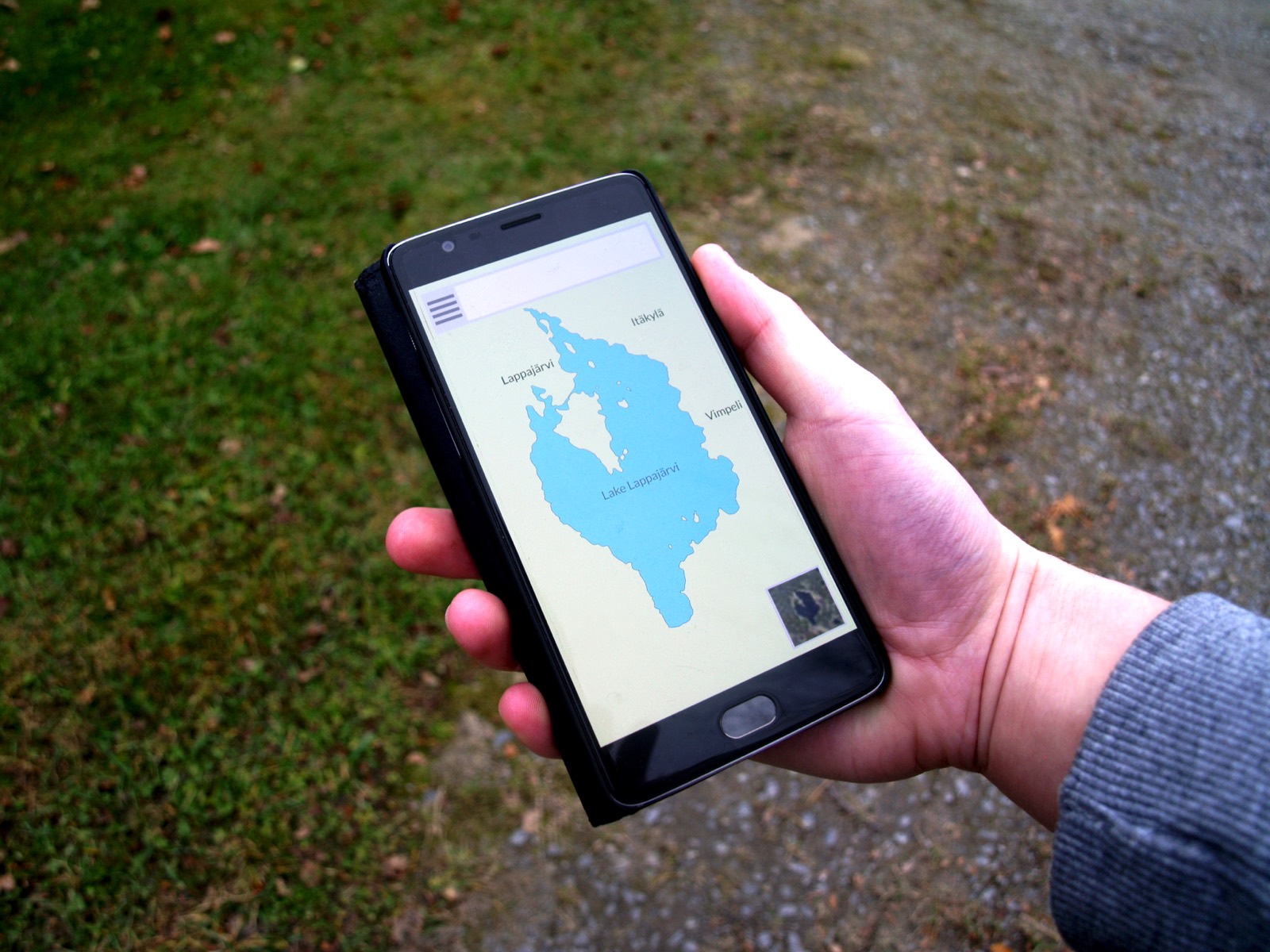 Smartphone affichant une application de carte, tenu à la main